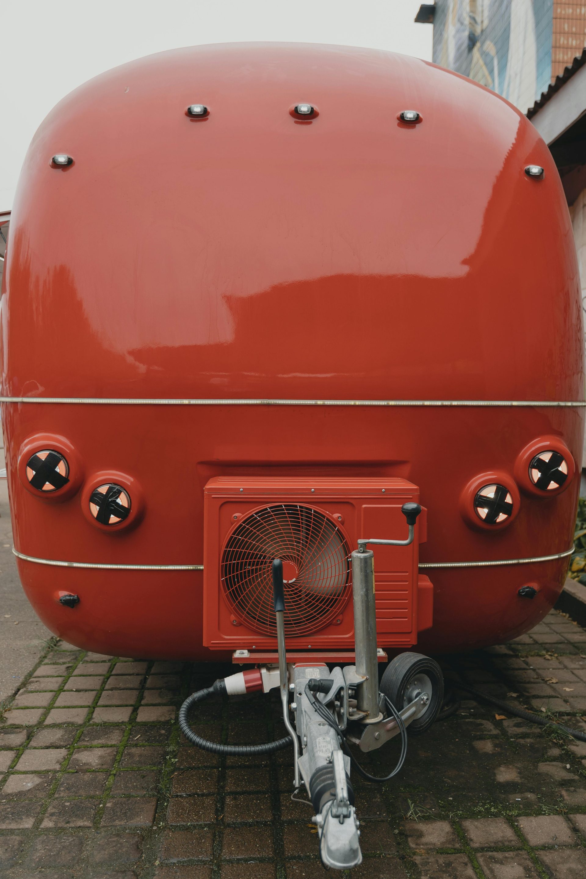 A vibrant red food truck parked on a paved street, showcasing its unique design.